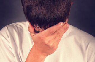 person grabbing his head with one hand