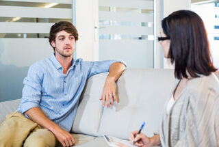 man sitting on couch in therapy