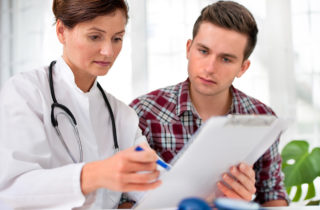 Female doctor showing paper to man