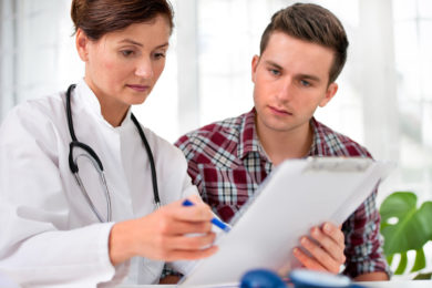 Female doctor showing paper to man